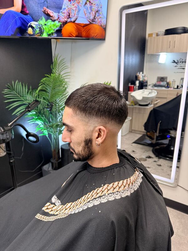 Side profile of a short cropped haircut with a low fade and trimmed beard