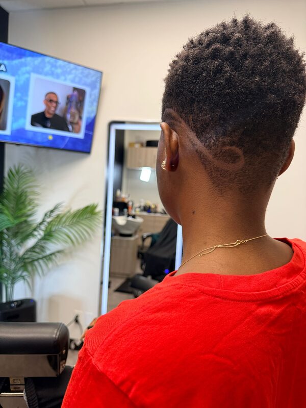 Back of a taper fade with a swirl hair-tattoo design shaved into the nape