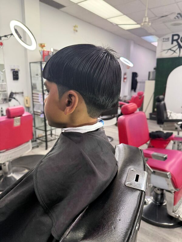 Side view of a sleek bowl-style haircut with straight bangs and a low fade
