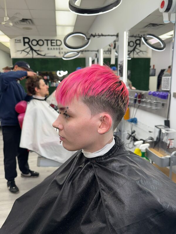 Side profile of a bright pink dyed fringe with a low fade undercut