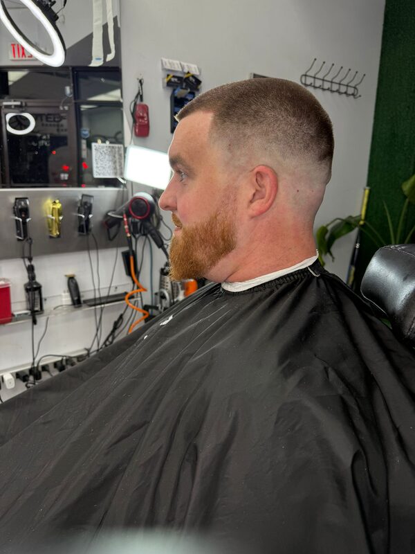 Side profile of a high-and-tight buzz cut with a ginger beard