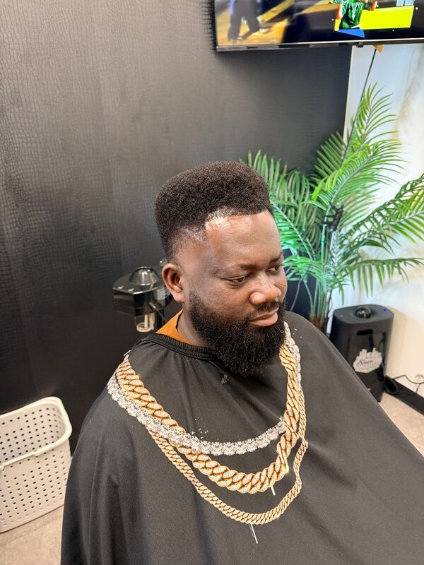 Side profile of a tall flat-top haircut with a taper fade and full beard