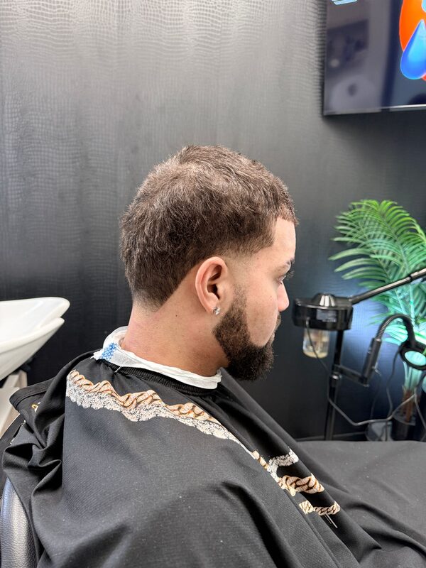 Back of the head showing a short wavy crop with a low fade and goatee