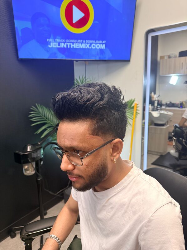 Side profile of a wavy brushed-up pompadour with a fade and full beard