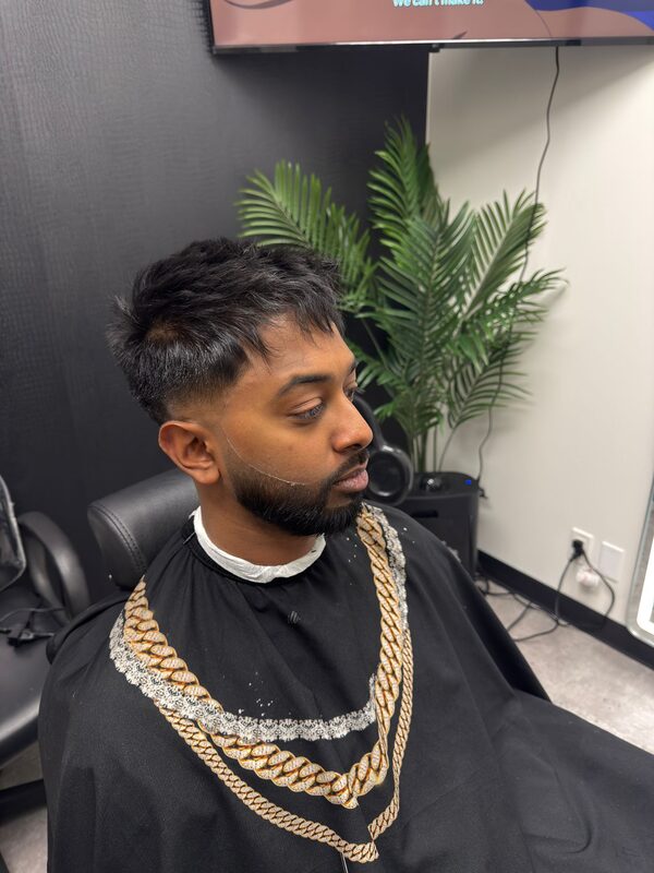 Side profile of a short curly crop with a taper fade and trimmed beard